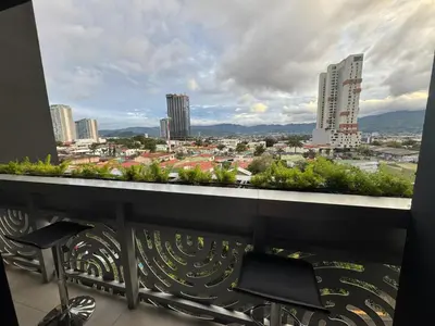 a balcony with chairs and a view of a city at Sky Escalante Apartment in San José