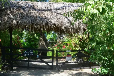 a hut with a sign in front of a fence at TreeTops Inn in San Juanillo