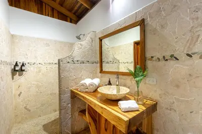 a bathroom with a sink and a mirror at Makanas Beach Bungalows in Santa Teresa Beach