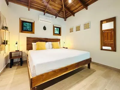 a bedroom with a large bed in a room at Makanas Beach Bungalows in Santa Teresa Beach