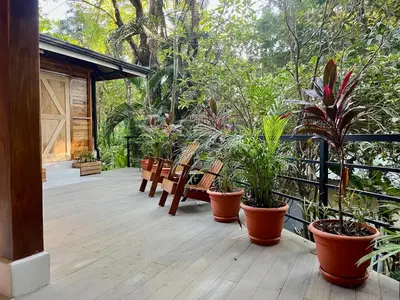 a porch with a bunch of potted plants on it at Makanas Beach Bungalows in Santa Teresa Beach