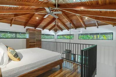 a bedroom with a bed and a ceiling fan at Makanas Beach Bungalows in Santa Teresa Beach