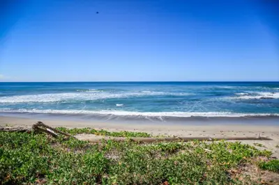 a view of the ocean from a sandy beach at Makanas Beach Bungalows in Santa Teresa Beach
