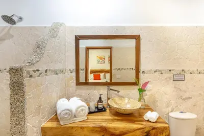 a bathroom with a counter with a sink and a mirror at Makanas Beach Bungalows in Santa Teresa Beach