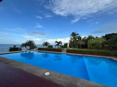 a large blue swimming pool next to the ocean at Caribbean View in Puerto Limón