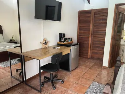 a room with a desk with a chair and a bed at Caribbean View in Puerto Limón