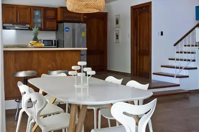 a kitchen and dining room with a white table and chairs at Villa Louise 4BR Modern Villa - Few Steps from the Beach in Santa Teresa Beach