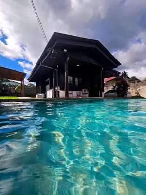 a pool of water in front of a building at Cabana los Tutos, relajate y disfruta in Fortuna