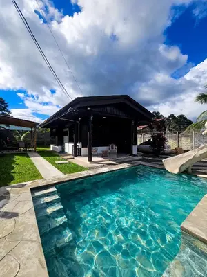 a swimming pool in front of a house at Cabana los Tutos, relajate y disfruta in Fortuna