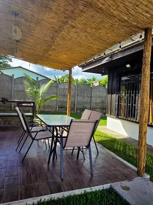 a patio with a table and chairs under a roof at Cabana los Tutos, relajate y disfruta in Fortuna
