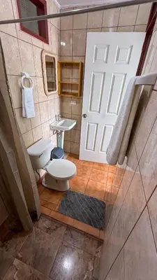 a bathroom with a toilet and a sink and a door at Brumas de Valverde in Monteverde Costa Rica