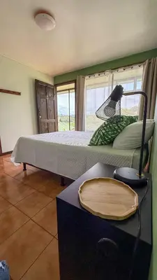 a bedroom with a large bed with a window at Brumas de Valverde in Monteverde Costa Rica