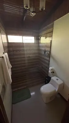 a bathroom with a toilet and a glass shower at Brumas de Valverde in Monteverde Costa Rica