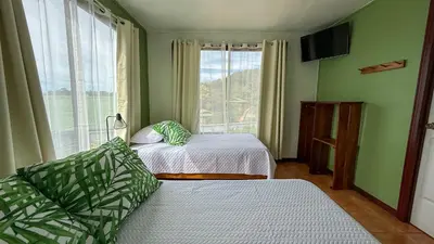 a bedroom with two beds and a large window at Brumas de Valverde in Monteverde Costa Rica
