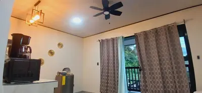 a living room with a ceiling fan and a window at Apartamentos Jireh in Quepos
