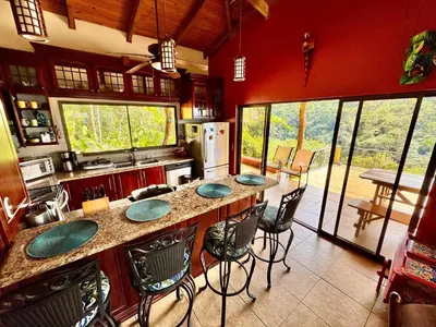 a kitchen with a large island with chairs around it at Cloud Forest Villas- Eco Lux - All Inclusive