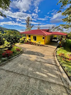 a yellow house with a red roof and a driveway at Cloud Forest Villas- Eco Lux - All Inclusive