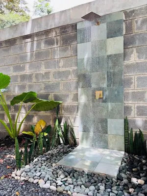 a shower in front of a brick wall at Alba Surfside - Villa Puerto Viejo in Tapantí