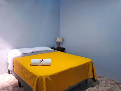 a yellow bed with a towel on top of it at Airport Nest Costa Rica Hotel in Alajuela City