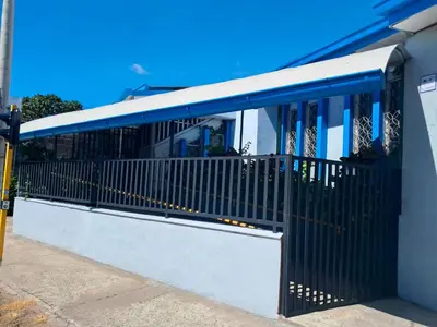 a black gate on the side of a building at Airport Nest Costa Rica Hotel in Alajuela City
