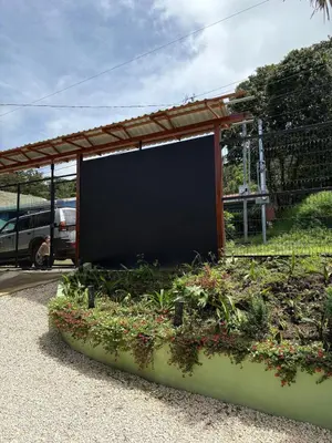 a garage with a large screen in a garden at Dreams of Golden Wings in Monteverde Costa Rica