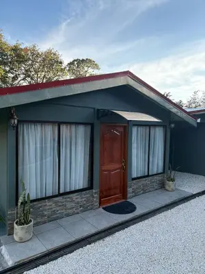 a small house with a brown door and windows at Dreams of Golden Wings in Monteverde Costa Rica