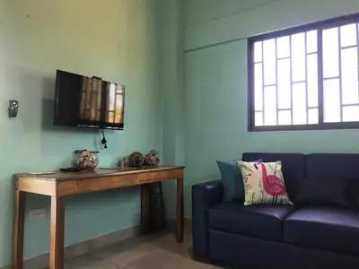 a living room with a couch and a table and a tv at Coco Loco Azul Boutique Apartments by Lucky Vacation Homes in Playa Junquillal