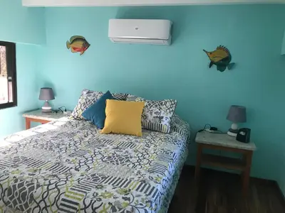 a bedroom with a bed with a blue wall at Coco Loco Azul Boutique Apartments by Lucky Vacation Homes in Playa Junquillal