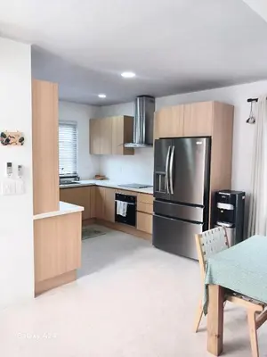 a kitchen with a stainless steel refrigerator and wooden cabinets at New house in Playa Hermosa in Playa Hermosa