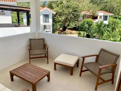 a balcony with two chairs and a table and a window at New house in Playa Hermosa in Playa Hermosa