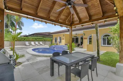 a patio with a table and chairs and a pool at Casa Brisa y Mar - Poolside Bliss, Walk to Beach in Bejuco