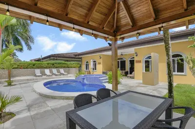 an outdoor patio with a table and chairs and a swimming pool at Casa Brisa y Mar - Poolside Bliss, Walk to Beach in Bejuco