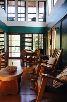 a room with chairs and a table and windows at Villa Del Sol Boutique Hotel in Coco