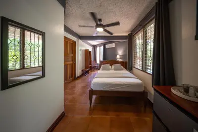 a bedroom with two beds and a ceiling fan at Villa Del Sol Boutique Hotel in Coco