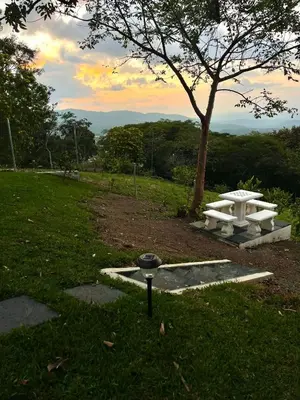 a white picnic table in a field with a tree at Villa Sura in Colón