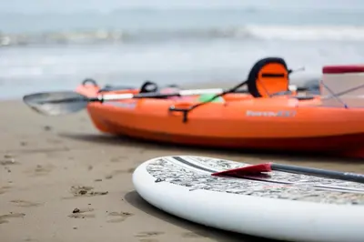 two kayaks and a paddle board on the beach at Kura Boutique Hotel Member of the Cayuga Collection in Uvita