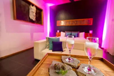 two glasses of wine on a table in a room at Kura Boutique Hotel Member of the Cayuga Collection in Uvita