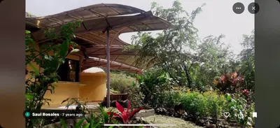 a house with an umbrella in a garden at LaCusuca in Guadalajara