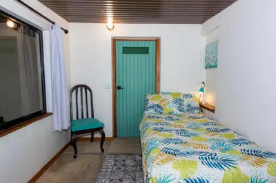 a bedroom with a bed and a chair and a door at Bhoga Forest