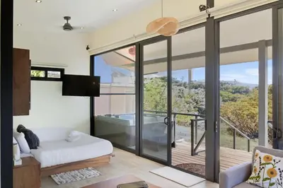 a living room with glass doors and a tub at Casas Oria Monteverde in Monteverde Costa Rica