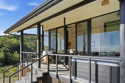 a house with glass doors and a balcony at Casas Oria Monteverde in Monteverde Costa Rica