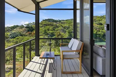 a room with a balcony with a couch and a table at Casas Oria Monteverde in Monteverde Costa Rica
