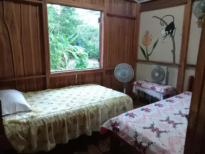 a bedroom with two beds and a window at Casa Almendros in Cabuya