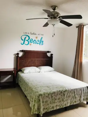a bedroom with a bed with a peace sign on the wall at COSTA LINDA Charming 1-03 in Jacó