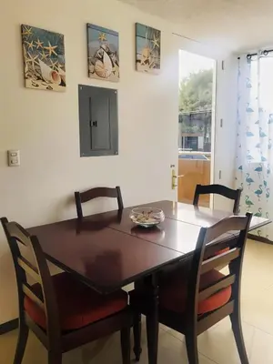 a dining room with a wooden table and chairs at COSTA LINDA Charming 1-03 in Jacó