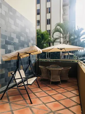 a patio with a table and an umbrella at COSTA LINDA Charming 1-03 in Jacó