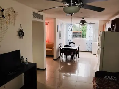 a kitchen and dining room with a table and refrigerator at COSTA LINDA Charming 1-03 in Jacó