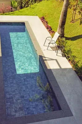 a swimming pool with a chair next to a palm tree at Casa Kimara in Uvita