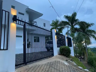 a gate in front of a house with a palm tree at Casa Kimara in Uvita