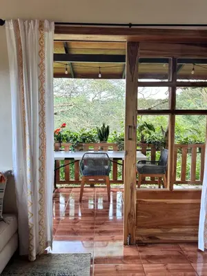 a screened in porch with a table and chairs at Cabaña Guapinol in Atenas